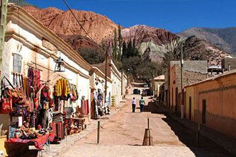 Street view of Purmamarca with colorful mountains in the background