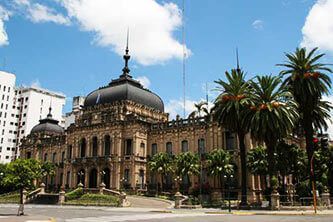 Historic building in Tucumán with palm trees and blue sky